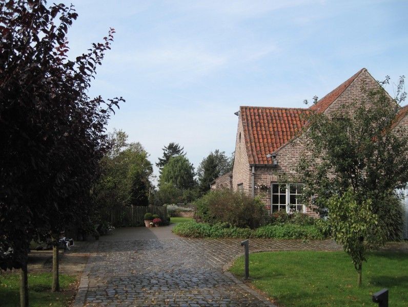 Rustikale Einfahrt zur Fruehstueckspension Kerselarenhof in Waarschoot, Ostflandern, mit ueppigen Gaerten.