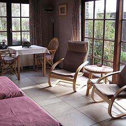 Entspannter Fruehstuecksraum im Kerselarenhof, Waarschoot, Ostflandern, mit Blick auf den Garten.