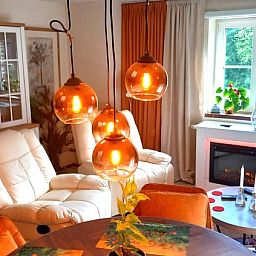 Gemuetliches Wohnzimmer im Le Grand Jardin, Bed & Breakfast in Neufchateau, mit warmer Beleuchtung und bequemen Sesseln.