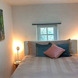 Erholsames Schlafzimmer im Le Grand Jardin, Bed & Breakfast in Neufchateau, Ardennen, mit weicher Bettwaesche und stimmungsvoller Beleuchtung.