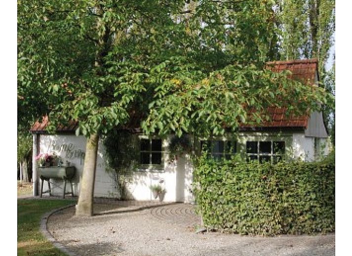 Charming vacation home BOMLOZE PUT in Sint-Laureins, Belgium with a rustic roof and surrounded by greenery.