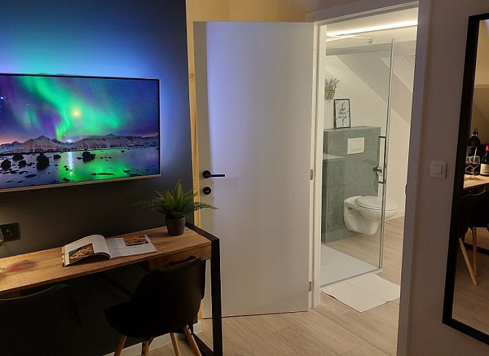 Cozy reading corner in B&B Viator Tongeren, Limburg with wine and plants for a relaxing stay.