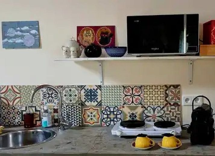 Stijlvolle keukenhoek met kleurrijke tegels bij Stay with the artist B&B in Teuven, Limburg.