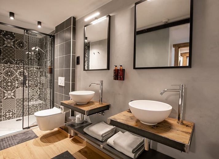 Gezellige slaapkamer in Vakantiehuisje in Stoumont, Ardennen, met rustieke houten balken en comfortabele inrichting.