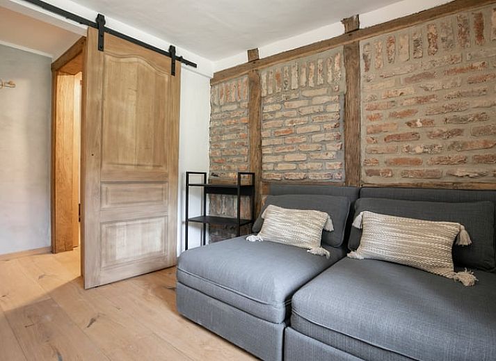 Sfeervolle zithoek met kunst en vintage meubels in Vakantiehuisje in Stoumont, Ardennen.