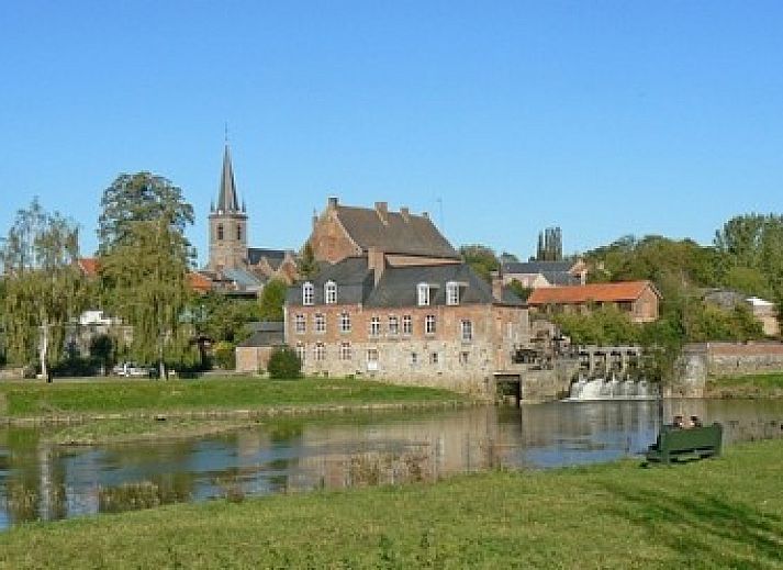 Gezellige binnenruimte van La Rose Laitiere in Saint Martin Sur Ecaillon, Henegouwen, met rustieke inrichting en zonlicht.