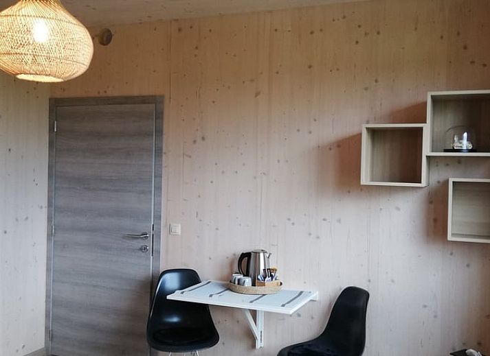 Exterieur van Vakantiehuisje in Tailles, Ardennen. Moderne architectuur met stenen en houten elementen en een zonnig terras.