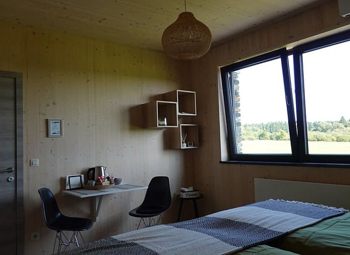 Exterieur van Vakantiehuisje in Tailles, Ardennen. Moderne architectuur met stenen en houten elementen en een zonnig terras.