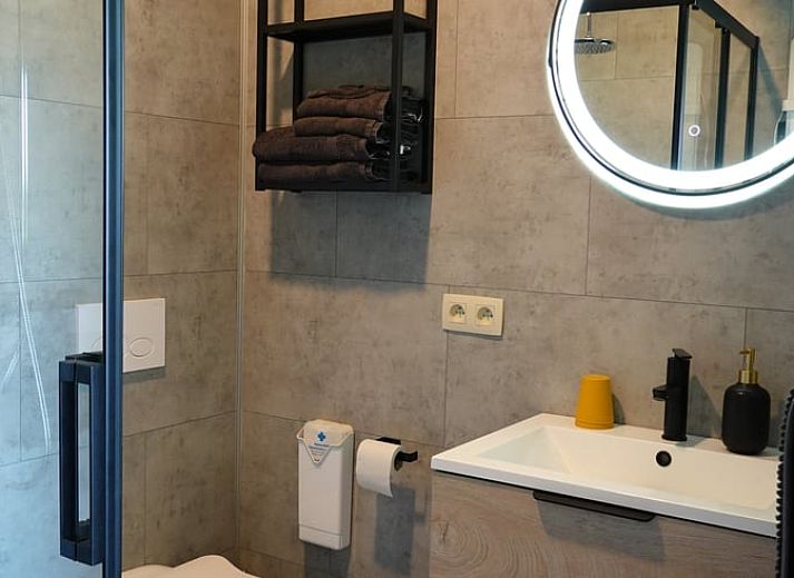 Exterieur van Vakantiehuisje in Tailles, Ardennen. Moderne architectuur met stenen en houten elementen en een zonnig terras.