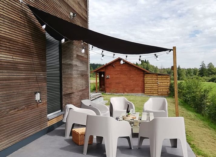 Vakantiehuisje in Tailles, Ardennen bij zonsondergang. Rustieke charme met picknicktafel en uitzicht op de omliggende natuur.