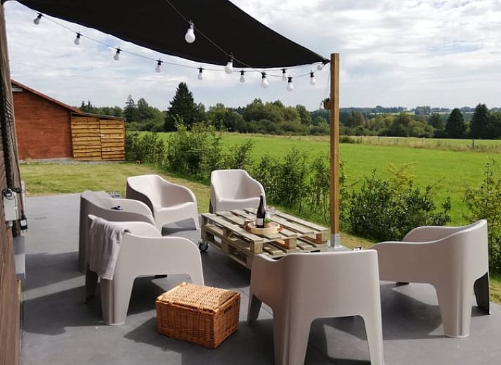 Vakantiehuisje in Tailles, Ardennen bij zonsondergang. Rustieke charme met picknicktafel en uitzicht op de omliggende natuur.