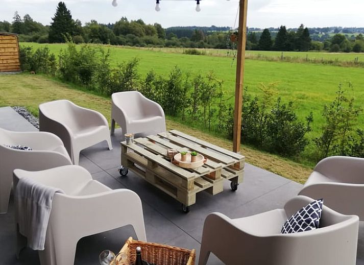 Vakantiehuisje in Tailles, Ardennen bij zonsondergang. Rustieke charme met picknicktafel en uitzicht op de omliggende natuur.
