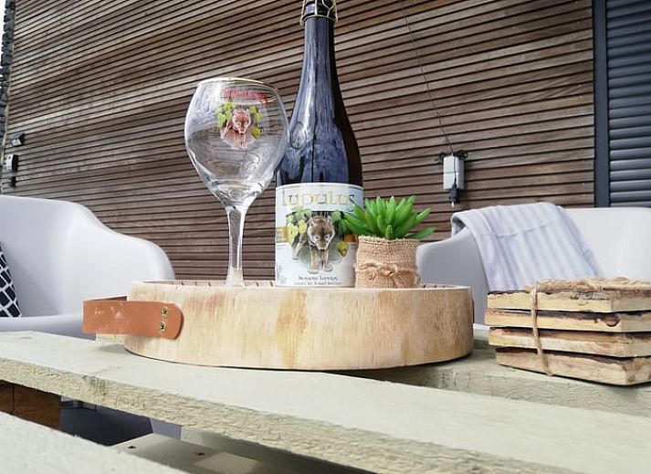 Vakantiehuisje in Tailles, Ardennen bij zonsondergang. Rustieke charme met picknicktafel en uitzicht op de omliggende natuur.