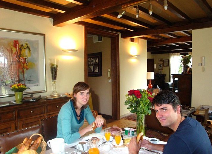 Gemuetliches Wohnzimmer im B&B YACA, De Haan, mit Holzbalken und einer einladenden Atmosphaere.