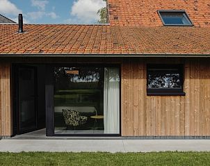 Moderne veranda bij B&B de Zunne in Leisele, West-Vlaanderen, met uitzicht op de tuin.