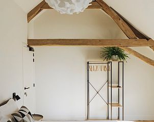 Lichte slaapkamer in B&B de Zunne, Leisele, West-Vlaanderen, met houten balken en moderne inrichting.