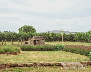 Uitzicht op de tuin van Landgoed Argiliere, B&B in Poperinge, met weids groen landschap.