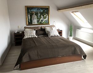 Comfortabele slaapkamer in Chez-Marraine B&B, Lissewege, West-Vlaanderen, met kunst en natuurlijk licht.