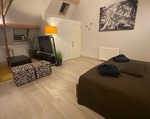 Ruime slaapkamer met zitgedeelte in Chez-Marraine B&B, Lissewege, West-Vlaanderen, voor ultiem comfort.