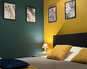 Stijlvolle slaapkamer in Chez-Marraine B&B, Lissewege, West-Vlaanderen, met kleurrijke accenten.