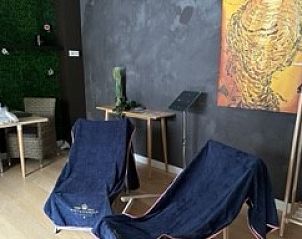 Ontspanningshoek in Chez-Marraine B&B, Lissewege, West-Vlaanderen, met comfortabele stoelen en kunst.