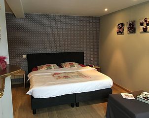 Moderne slaapkamer met kunst aan de muur in B&B De Zoete Kers, Wakken.