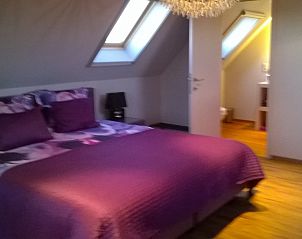 Sfeervolle slaapkamer met paarse accenten in B&B De Zoete Kers, Wakken.