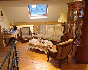 Comfortabele zithoek in Varlet Farm bed and breakfast, Poelkapelle, met houten interieur en vintage meubels.