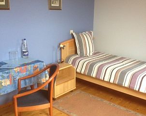 Eenpersoonskamer met blauwe muren in Varlet Farm bed and breakfast, Poelkapelle, met bureau en stoel.