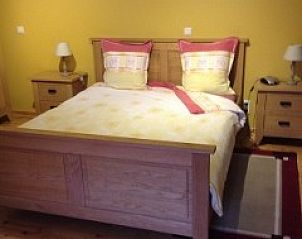 Kamer met tweepersoonsbed in Varlet Farm bed and breakfast, Poelkapelle, met warme houten meubels.