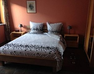 Knusse slaapkamer met tweepersoonsbed in Varlet Farm bed and breakfast, Poelkapelle, met rode accenten.