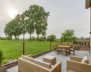 Geniet van het terras bij Bed en Vrijheid B&B, Peer, met uitzicht op groene velden.