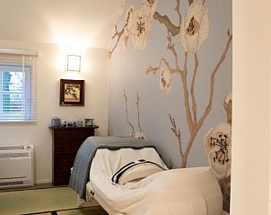 Rustgevende slaapkamer met kunst aan de muur bij Wabi Sabi B&B in Peer, Belgi.