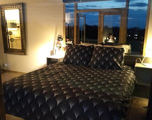 Gezellige slaapkamer in De Lodge, een bed and breakfast in Grote-Spouwen, Limburg, met uitzicht op de avondlucht.