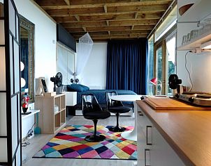 Stijlvolle binnenruimte van De Lodge bed and breakfast in Grote-Spouwen, Limburg, met moderne inrichting en kleurrijk tapijt.