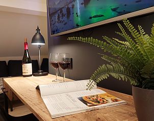 Knusse leeshoek in B&B Viator Tongeren, Limburg met wijn en planten voor een ontspannen verblijf.