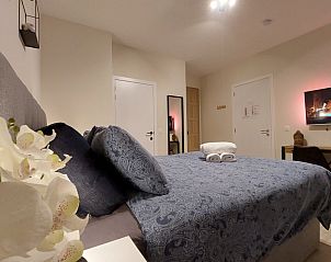 Slaapkamer in B&B Viator Tongeren, Limburg met comfortabel bed en sfeervolle verlichting.