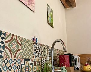 Stijlvolle keukenhoek met kleurrijke tegels bij Stay with the artist B&B in Teuven, Limburg.